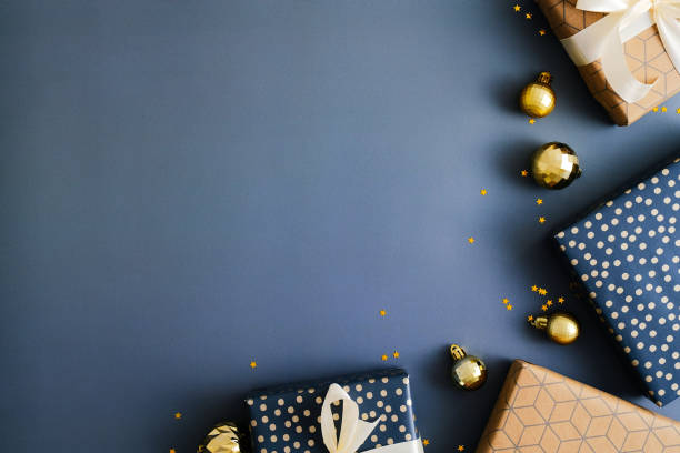 istock Dark blue Christmas background with gift boxes and gold baubles. Flat lay, top view, copy space. 1356907410