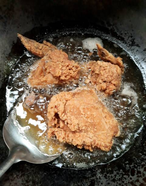 istock Frying Chicken in cooking pan - food preparation. 1356907499