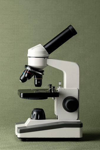 Close-up of a microscope on a green background.