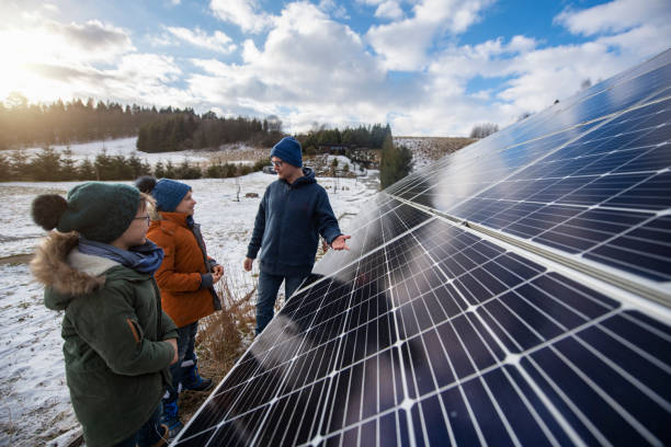 istock Father explaining solar panels technology to the kids on a winter day. 1356908370