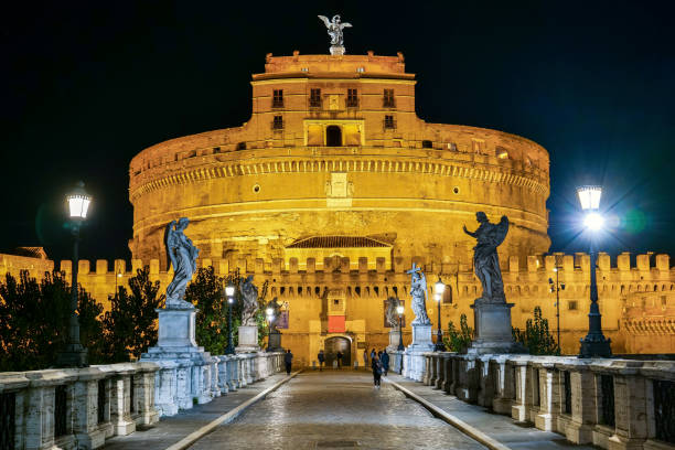 una suggestiva scena notturna lungo ponte sant'angelo sul fiume tevere nel cuore storico e barocco di roma - hadrians tomb foto e immagini stock