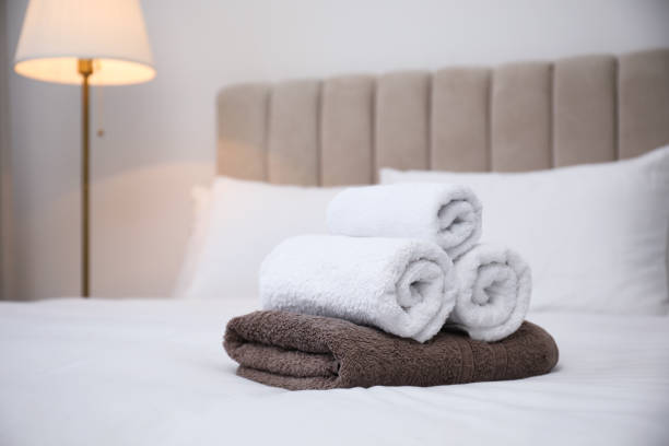 istock Soft clean towels on white bed indoors. Space for text 1356909693