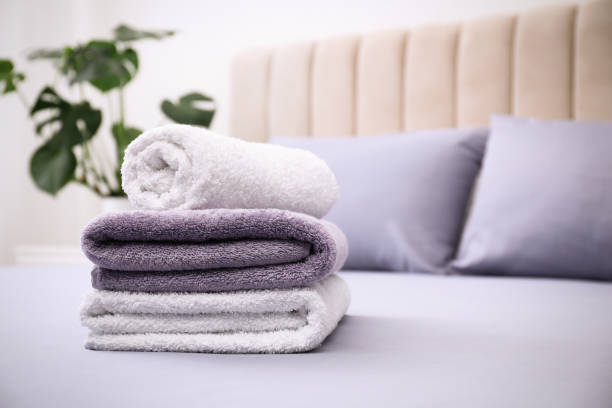 istock Soft clean towels on bed indoors. Space for text 1356909740