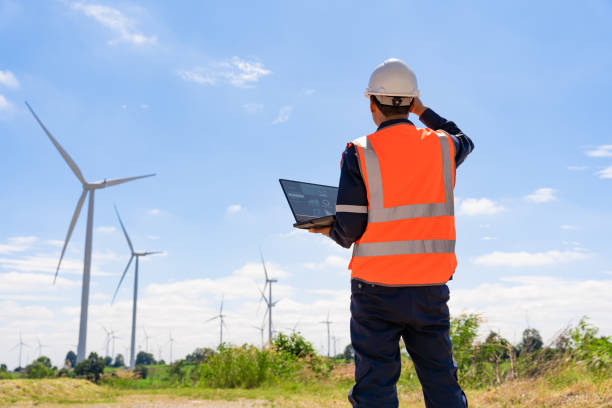 l'ingegnere cammina per controllare gli impianti eolici con controllare le prestazioni. le turbine eoliche sono una fonte di elettricità alternativa per essere risorse sostenibili in futuro. il concetto di energia pulita salva il mondo - farm scenics landscape alternative energy foto e immagini stock