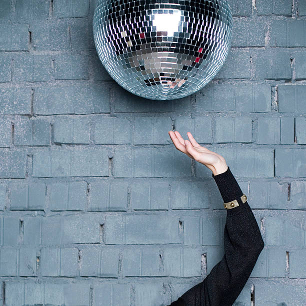 istock female hand trying to reach a discoball 135691420