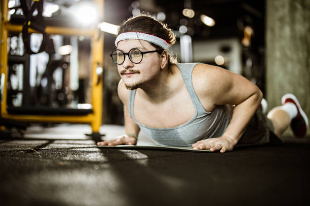 istock Nerdy male athlete exercising push-ups in a gym. 1356915528
