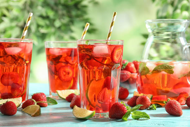 istock Refreshing drink with strawberry and lime on light blue wooden table 1356916628