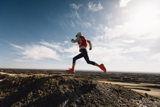mujer corredora de trail country corriendo en la cima de la colina del desierto de arena - carrera de campo través fotografías e imágenes de stock