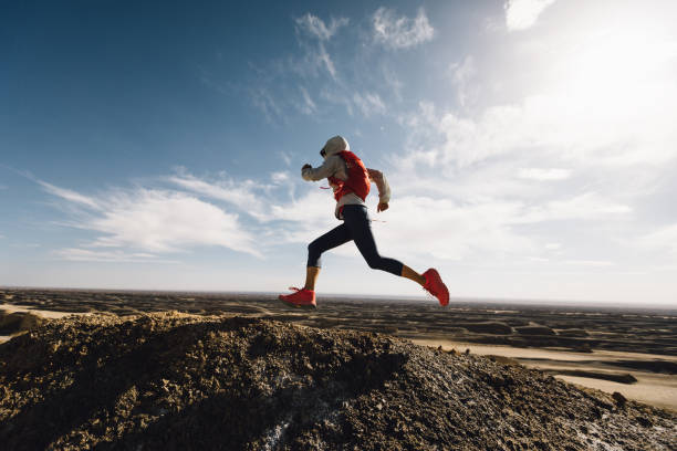 นักวิ่งเทรลหญิงข้ามประเทศวิ่งบนยอดเขาทะเลทรายทราย - cross country running ภาพสต็อก ภาพถ่ายและรูปภาพปลอดค่าลิขสิทธิ์