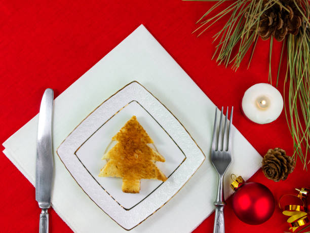 istock Christmas table setting toast white plate silverware red tablecloth background New year restaurant dinner decoration 1356918616