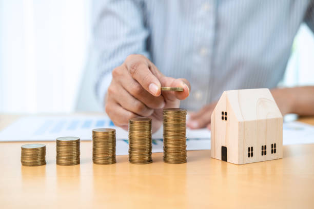 istock Asian business man putting coin increase on coins stacking with house model while preparation to saving 1356919632