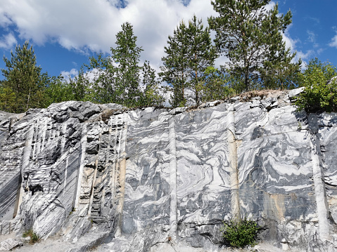 Italian quarry with smooth sections of marble in the Ruskeala Mountain Park on a sunny summer day.