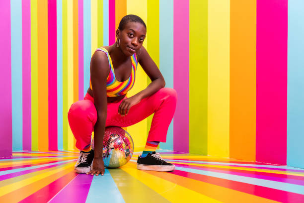 istock Beautiful young woman dancing and having fun inside a rainbow box room 1356920109
