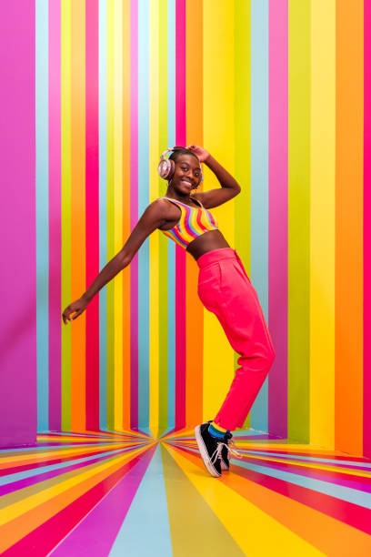 istock Beautiful young woman dancing and having fun inside a rainbow box room 1356920141