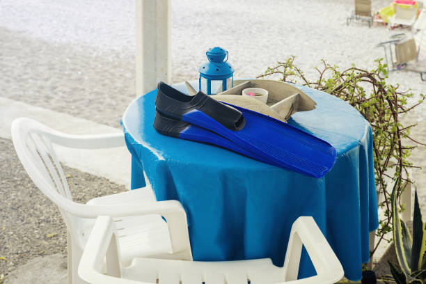 Blue flippers and candle holders on a table near the beach