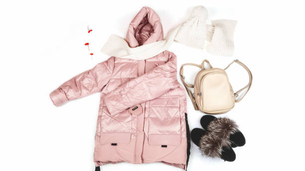 istock Warm jacket with a backpack, scarf and boots on a white background. Women's stylish autumn or winter clothes. Cozy winter look. Flat lay, top view. 1356921438