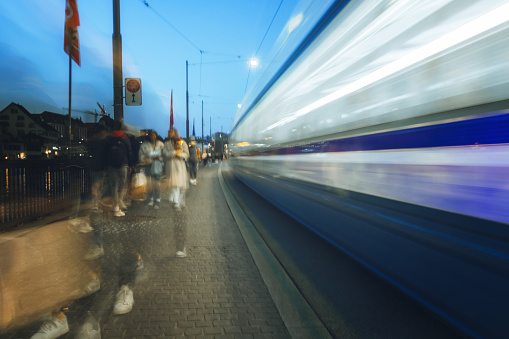 motion blure of blue tram and pedestrian  in zurich old town at sunset hour