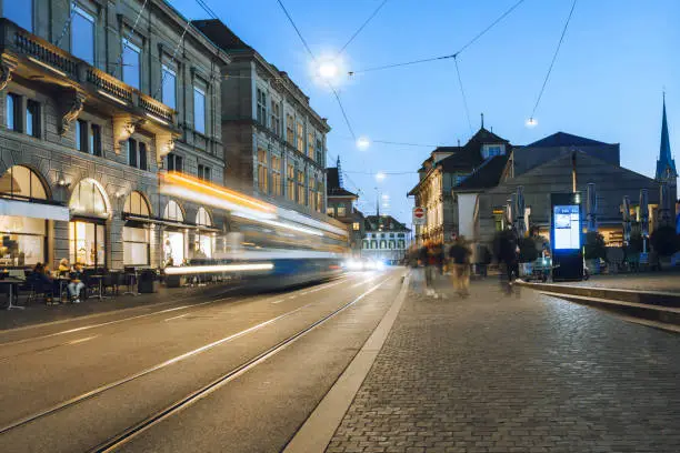 long exposure of blue tram on zurich street at blue hour