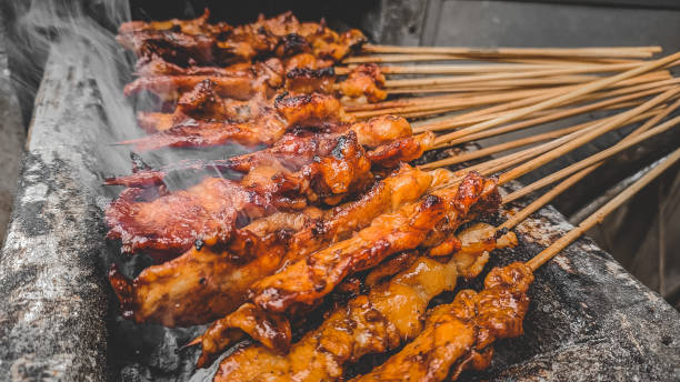 istock Chicken satay being grilled on a traditional grill 1356922449
