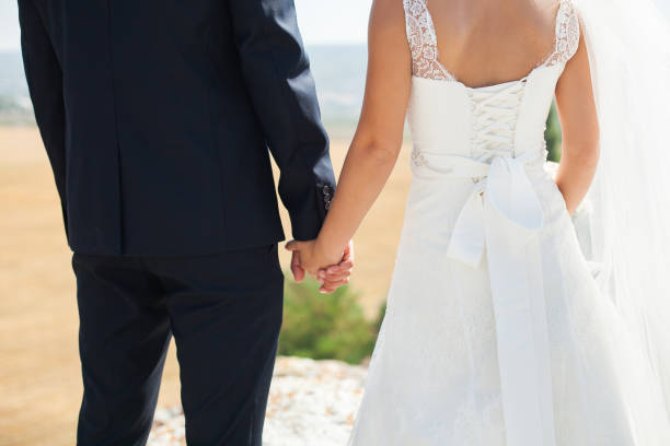 istock Bride and groom walking together holding their hands 1356924670