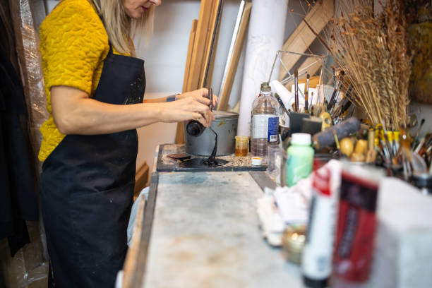 istock Unrecognizable female artist, pouring ink, prepare it for usage 1356927107