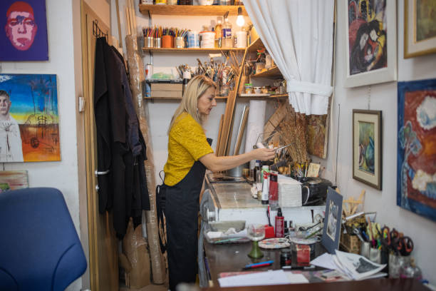 istock Female artist, preparing her messy studio, so she can strat to make art 1356927559