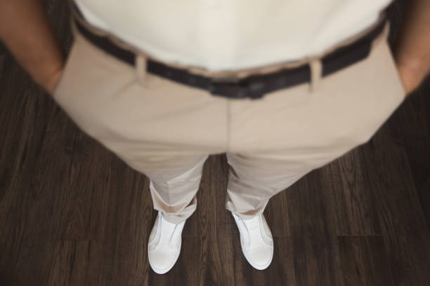 Businessman tying shoe laces indoors, close up