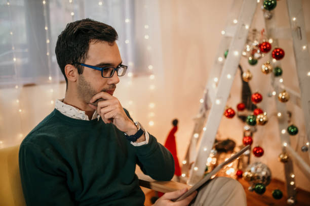 istock Modern young man using tablet at home for Christmas 1356928419