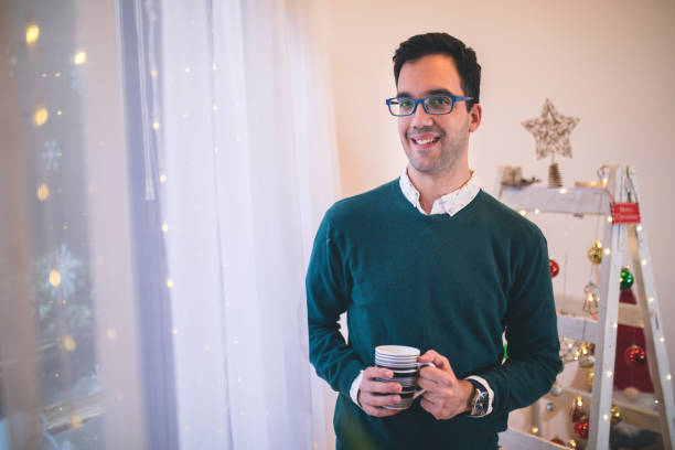 istock Attractive man drinking tea on Christmas morning 1356929822