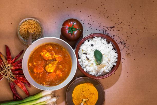 istock Madras chicken curry, rice and condiments in small bowl. 1356929825