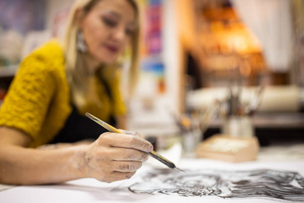 istock Female artist adding details on the lithography art she made 1356930253