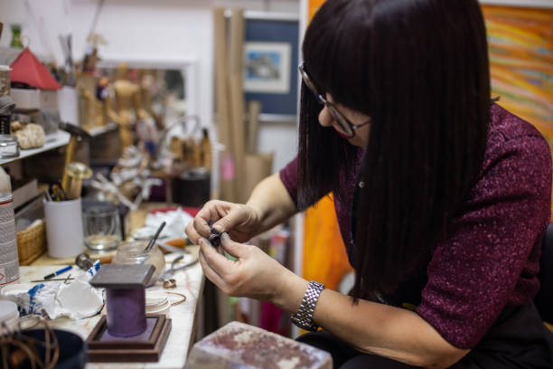 istock Focused female craft person, making a ring in her workshop 1356930384