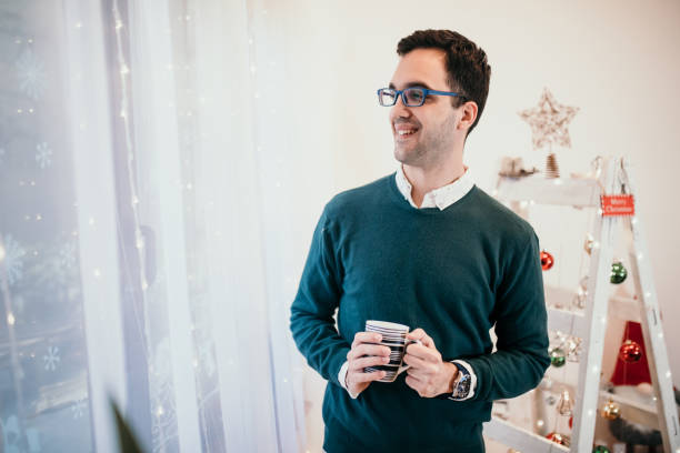 istock Attractive man drinking tea on Christmas morning 1356930736
