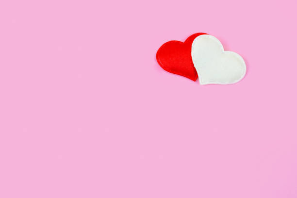 istock Minimalistic pink background with two hearts in the upper corner 1356934843