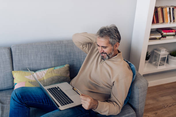 istock Man enjoying on the sofa and working online 1356935422