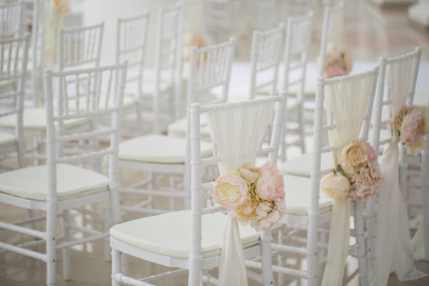 istock wedding decorations flowers on chairs. Wedding exit registration, white chairs decorated for wedding. wedding setup detail. 1356935467