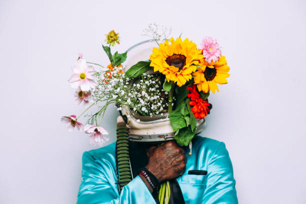 istock Fine art concept with man wearing a space helmet and flowers composition 1356935983