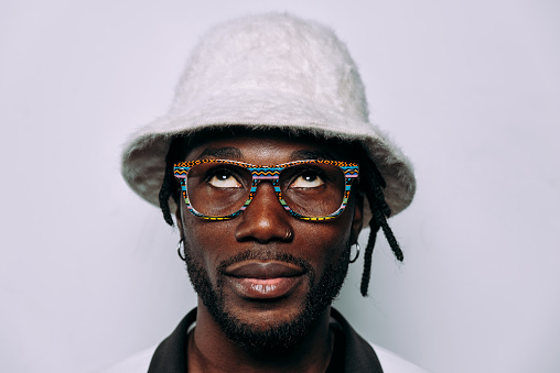 portrait of an hip hop music musician. Cinematic image of a man wearing white clothes and jewels