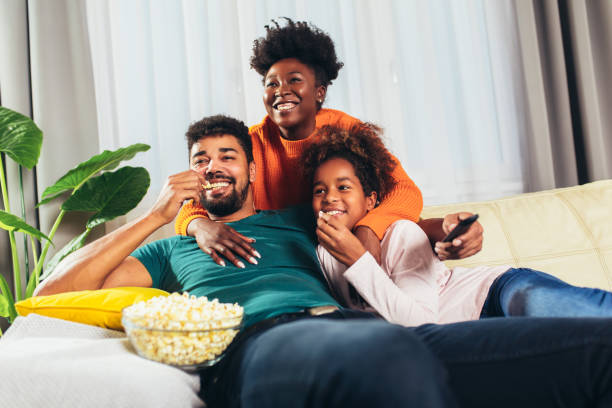 Relaxed african american family watching tv together. stock photo