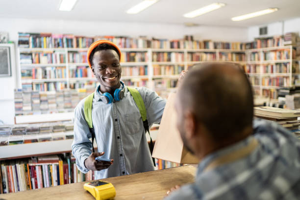Young man paying in a thrift store