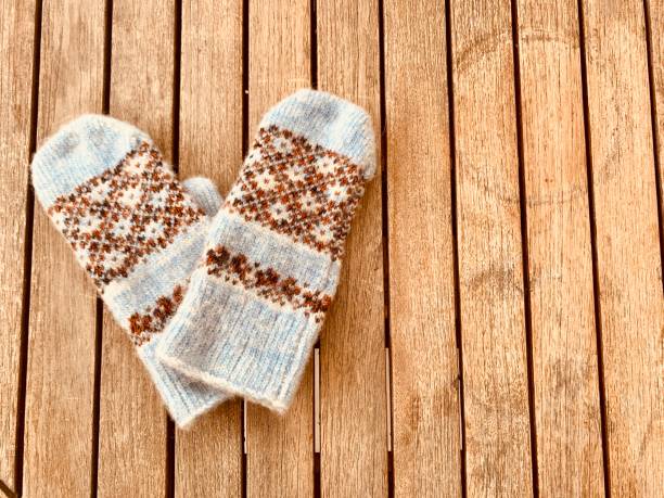 A pair of mittens on wooden background . Copy space