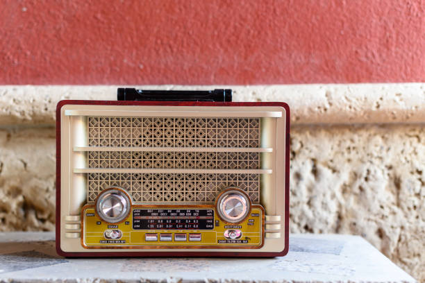 radio antigua roja y amarilla sobre un fondo rústico - radio old fashioned antique yellow fotografías e imágenes de stock
