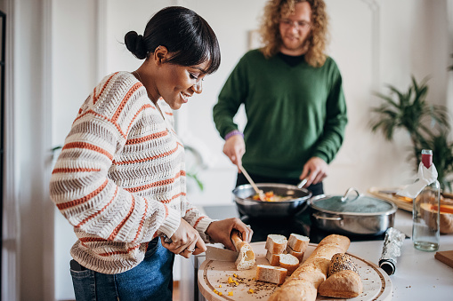 Two people, diverse couple preparing lunch together in domestic kitchen,