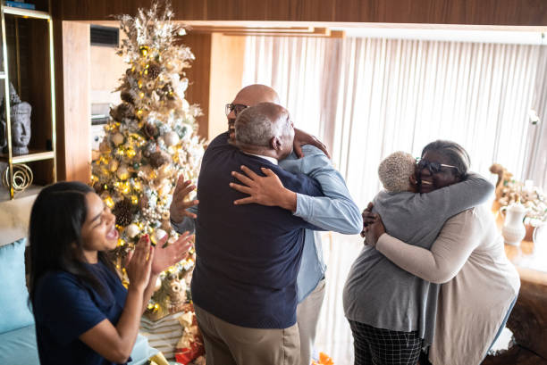 familia abrazando y adolescente aplaudiendo durante la navidad en casa - home interior arrival father family fotografías e imágenes de stock