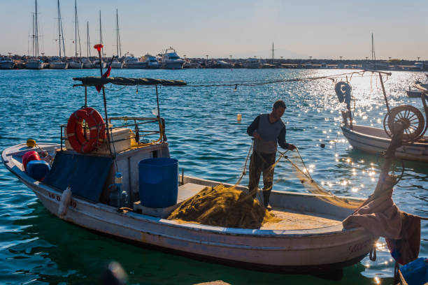 Fisherman in a quiet Aegean town Altınoluk, Balikkesir, Turkey - 14 June 2014 A fisherman preparing to go out to sea in Altınoluk, the pearl of the Aegean. kompozisyon stock pictures, royalty-free photos & images