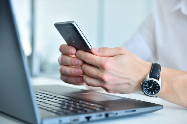 istock Businessman writes message on smartphone in office 1356948619