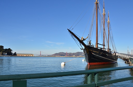 Gaze over the San Francisco Bay with a sailboat at anchor and the Golden Gate Bridge in the background