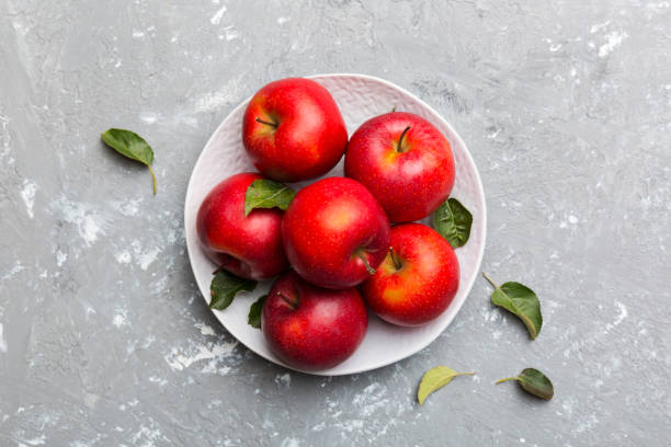 istock Many red apples on cement background, top view. Autumn pattern with fresh apple above view 1356950133