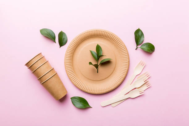 set of empty reusable disposable eco-friendly plates, cups, utensils on light white colored table background. top view. Biodegradable craft dishes. Recycling concept. Close-up