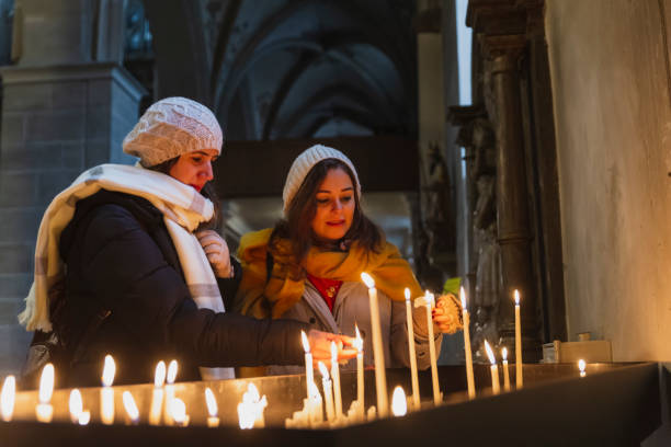 istock Womans in a church, lighting a candle 1356950706
